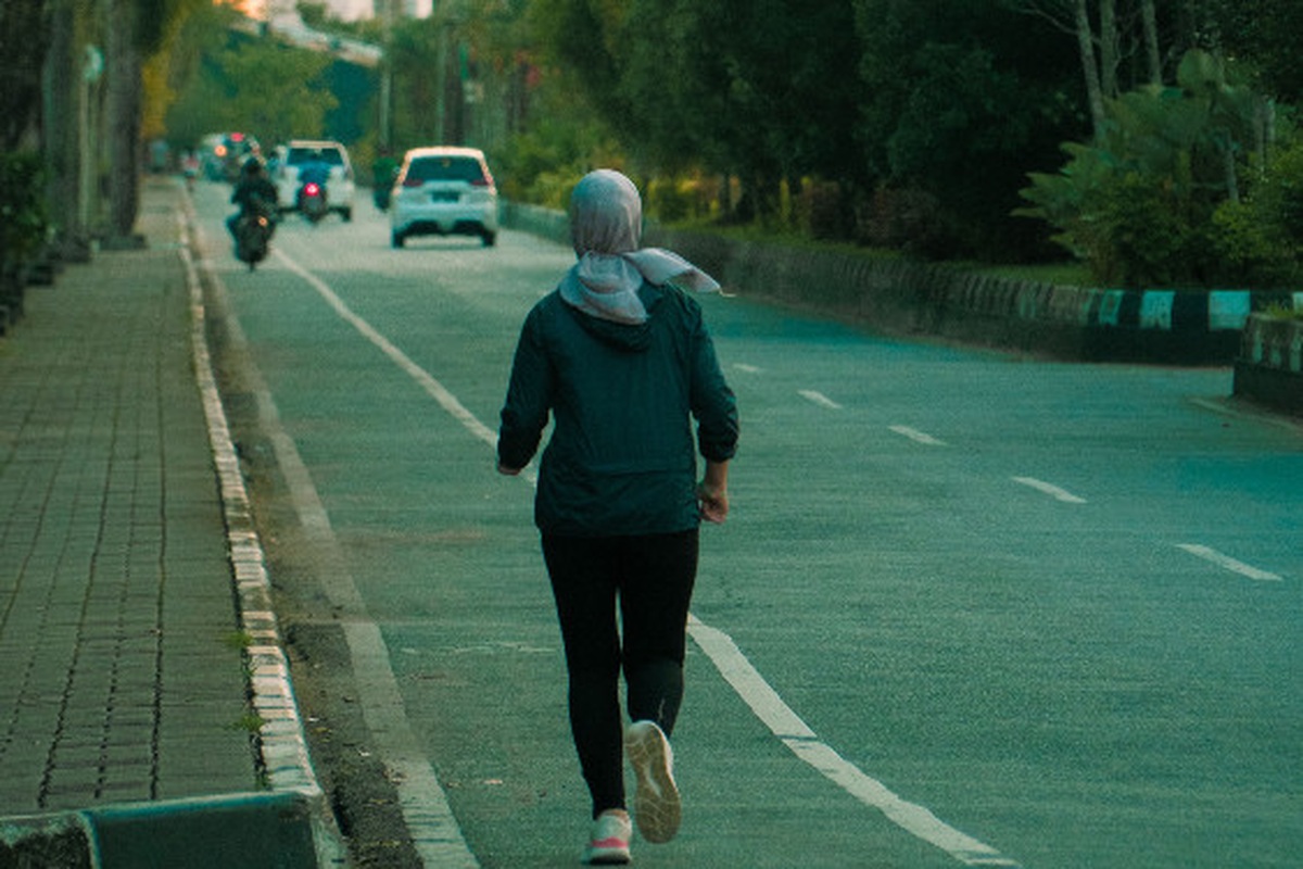 Runner training along a quiet road during an early morning session
