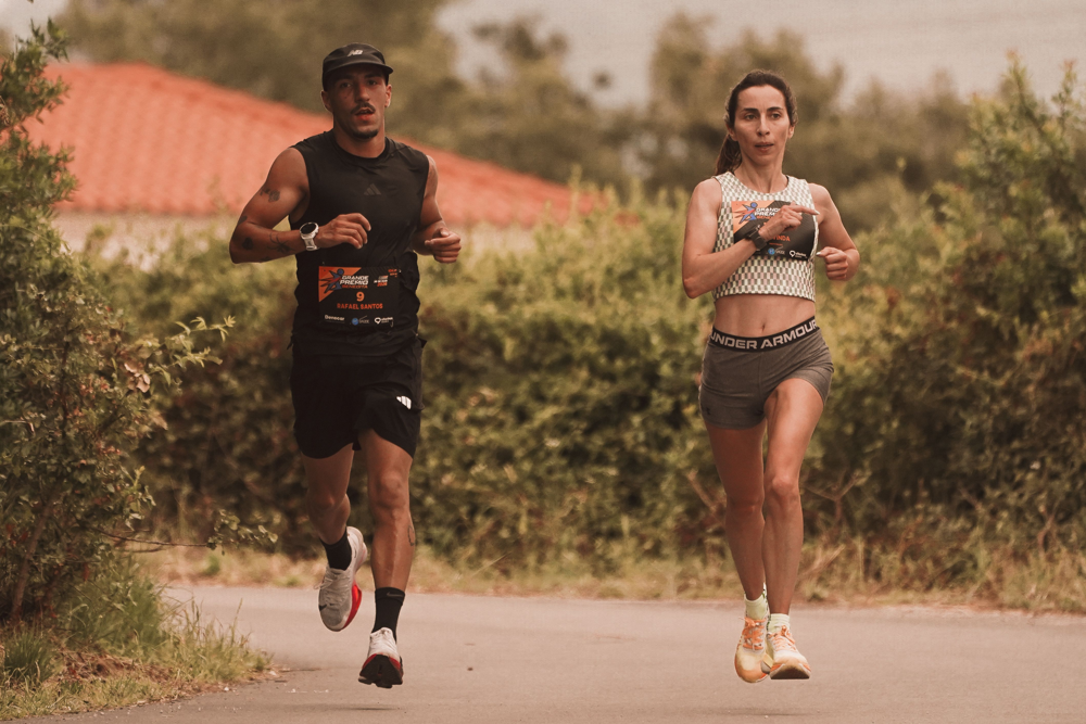 Two runners training together on an outdoor road during a structured season build