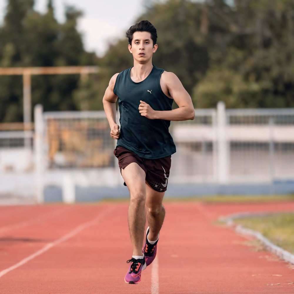 Runner training on an outdoor track as part of a structured training plan